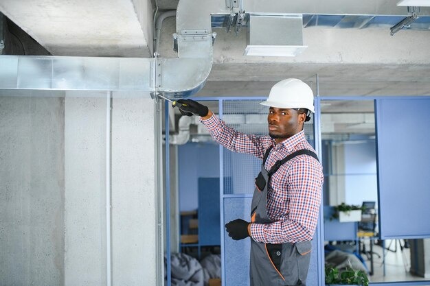 imgi 166 hvac african worker install ducted pipe system ventilation air conditioning copy space 255667 64635